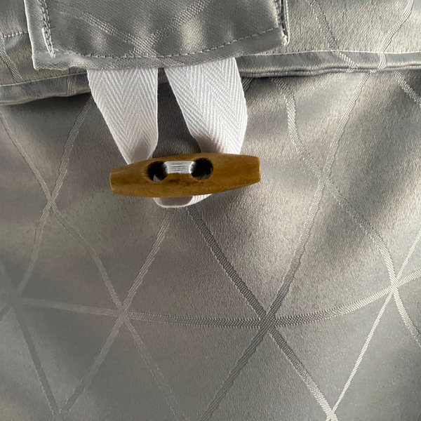 "Silberne Handtasche" mit einem beigen Holzknopf