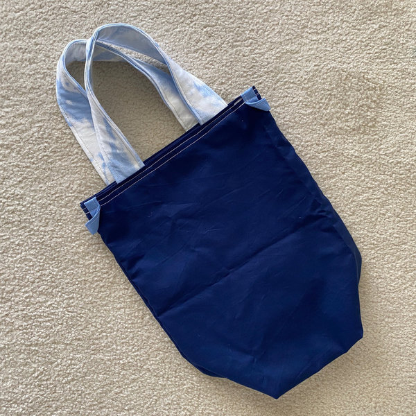Dunkelblaue Einkaufstasche mit hellblaumelierten Trägern
